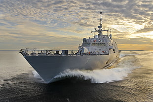 gray military ship on sea during sunsest