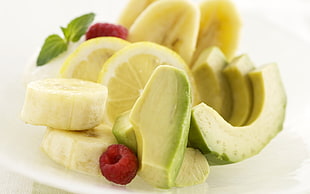 slice avocado, lemon, banana and berry serve on white plate