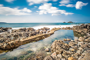 rock seaside with clear ocean wave under cloudy sky at day time, united kingdom