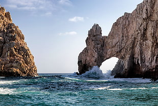 photography of brown rock mountain on green ocean sea during daytime, nature, arch, sea, waves