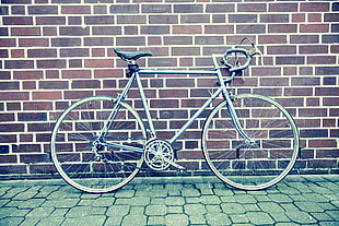 Teal and Black Road Bike Near Black and Brown Brick Wall HD wallpaper
