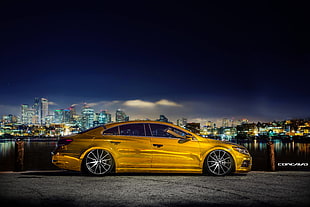 yellow sedan with background of city building
