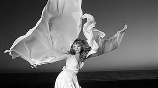 grayscale photography of a woman dancing beside sea