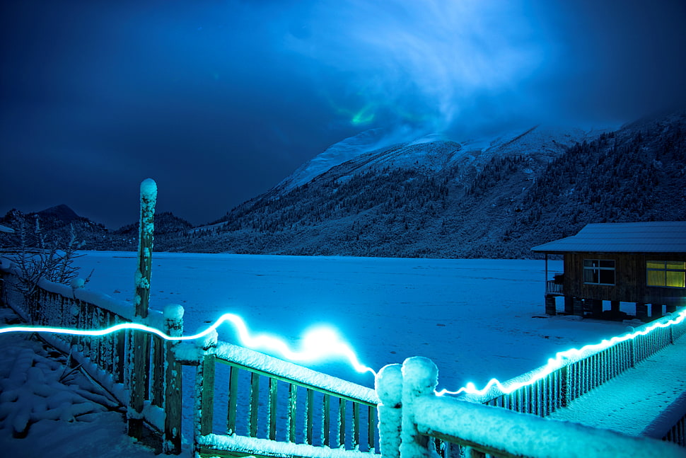 time lapse photo of string light near bridge and house on snow HD wallpaper