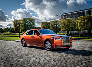 orange Rolls Royce sedan parked on gray road during daytime photo HD wallpaper