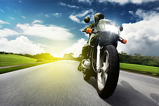 man riding motorcycle under blue and white sunny sky