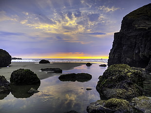 rock formation near ocean water during sunset HD wallpaper