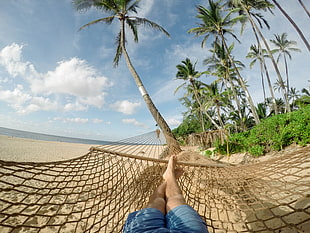 photo of person lying down in hammock during day time