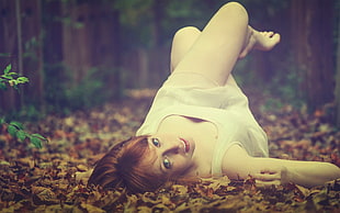 woman in white dress laying on dried grass
