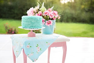 blue cake on pink footed cake dish