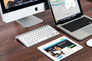 white iPad near iMac and MacBook Pro on table