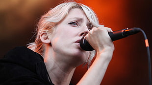 woman holding black microphone