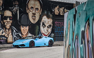blue Lamborghini Hucaran parked beside people painted wall