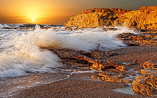 time lapse photography of seashore splashing wave to the rock