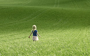 blonde haired girl on grass field