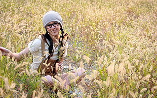 woman seating beneath a field of grass
