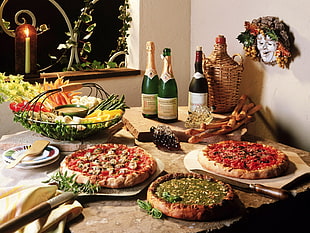 wine bottles near pizza on table