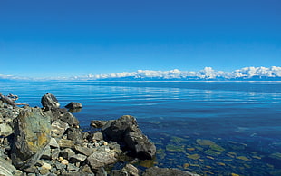 stack of rocks near body of water during daytime