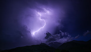 lightning strike above rock formation at night time