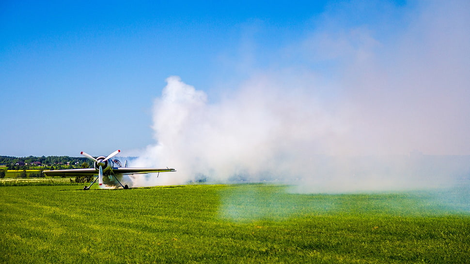 green grass field, airplane, smoke HD wallpaper