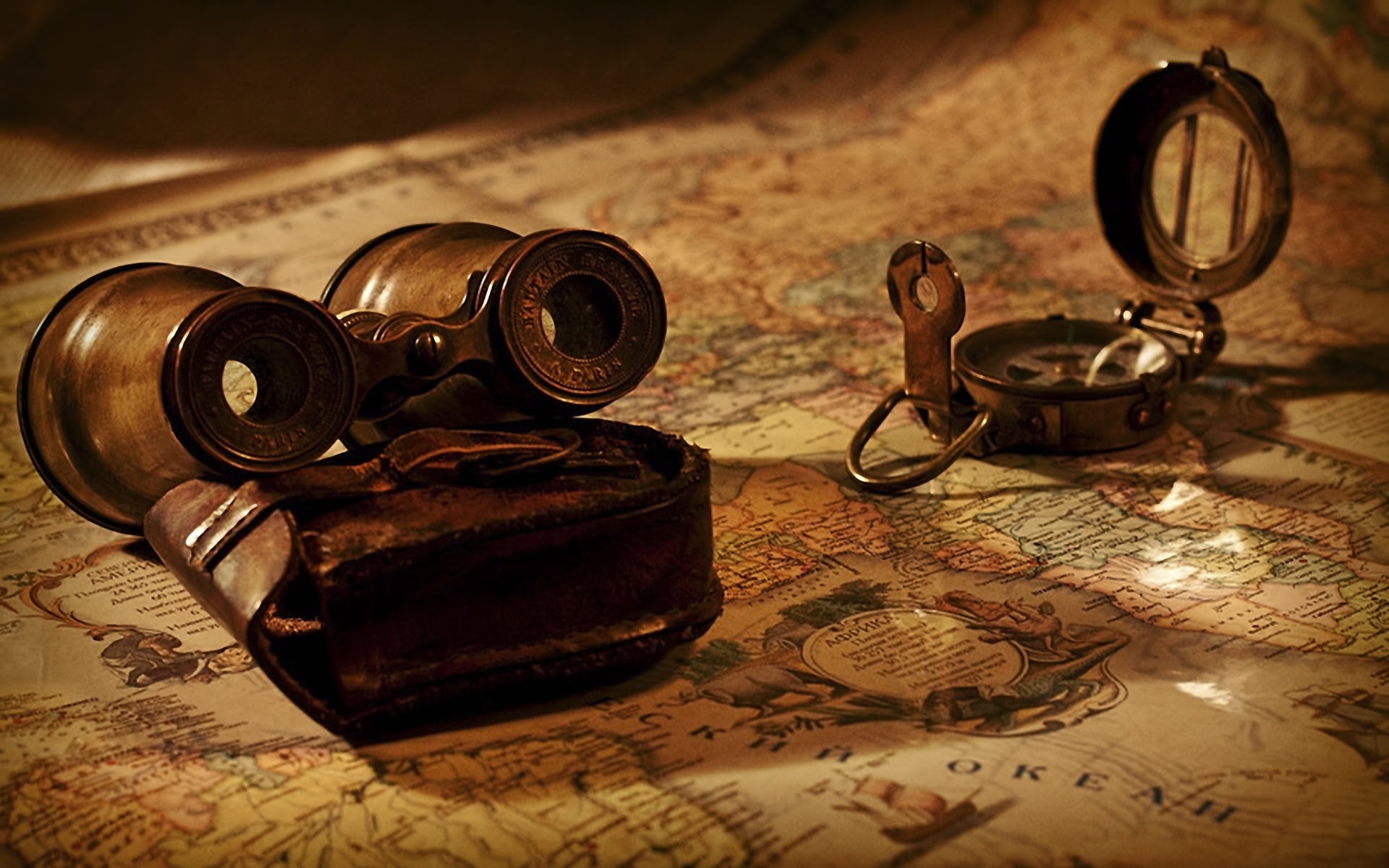 brown binocular and compass on world map