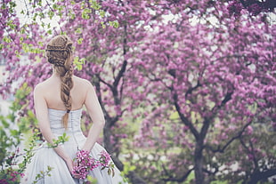 woman in white strapless dress standing on garden