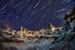 rock formation under meteor shower during nighttime HD wallpaper