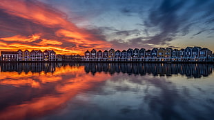 lined up buildings, reflection, sunset, water, Sun