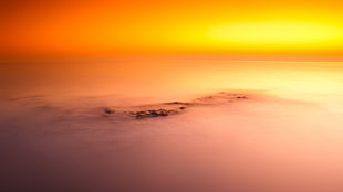 high angle photography of islet covered with fog during golden hour