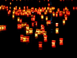 candle lantern on body of water during night time HD wallpaper