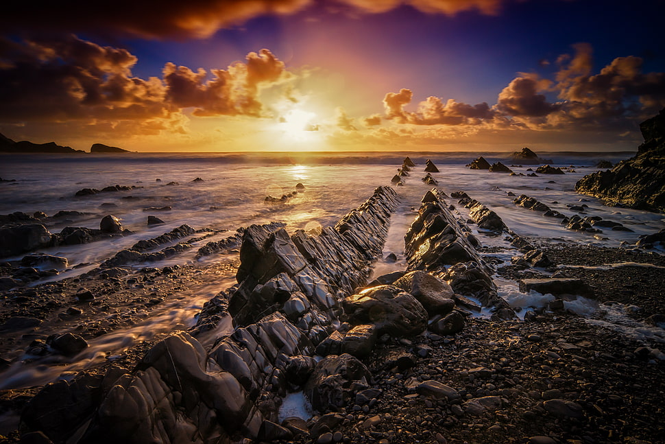 rock formation beside seashore under sunrise photography HD wallpaper