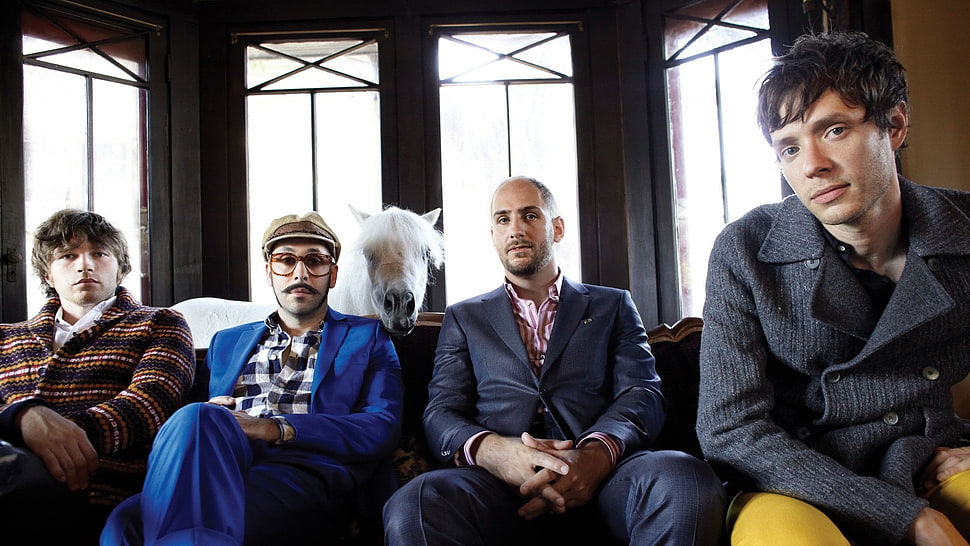 four men wearing assorted coats seat on sofa HD wallpaper