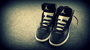 photo of black-and-white Air Jordan basketball shoes on gray surface