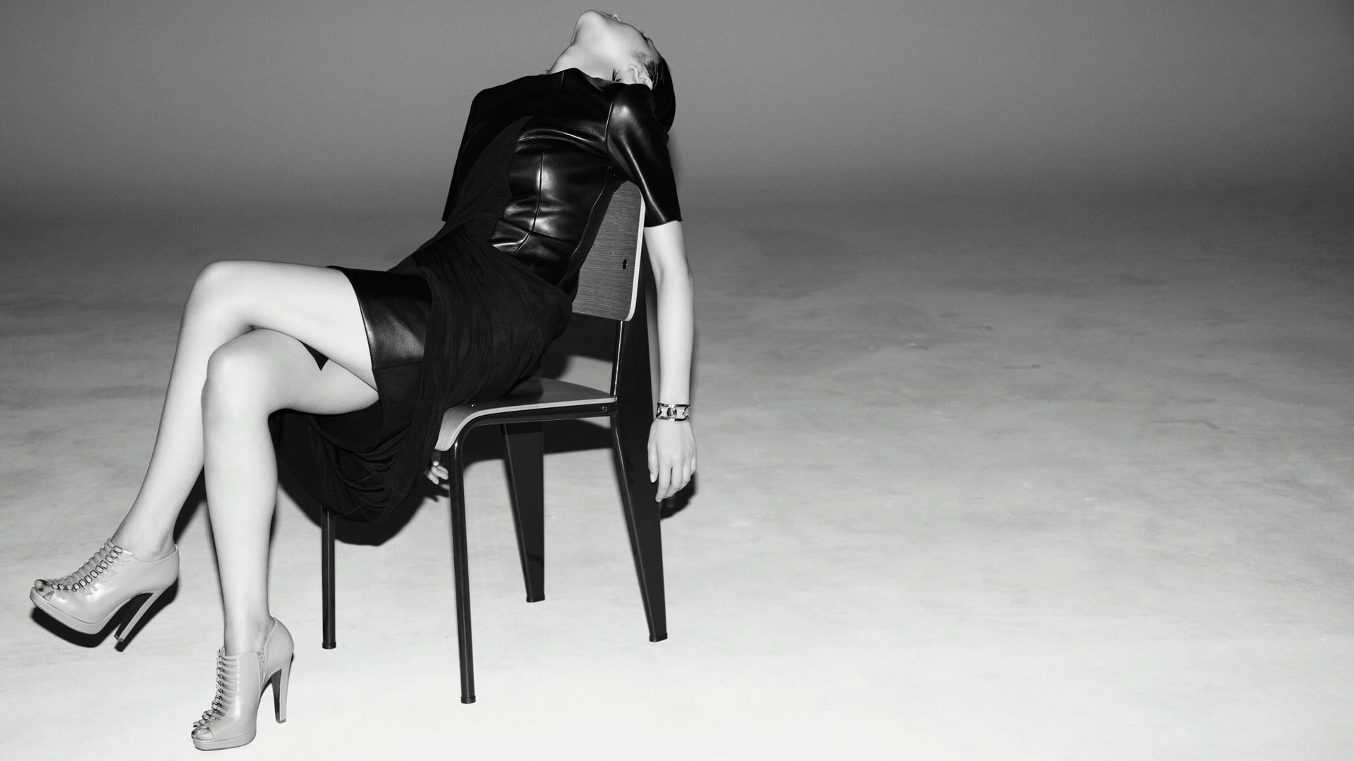 Black leather padded rolling armchair, monochrome, model, looking up ...