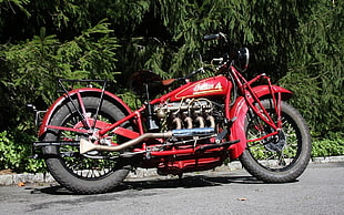red and grey cruiser motorcycle parked beside trees during daytime