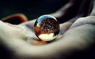 marble on person's hand photography HD wallpaper