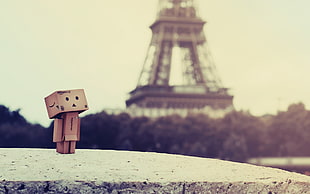 brown cardboard box cartoon character standing beside tower during daytime