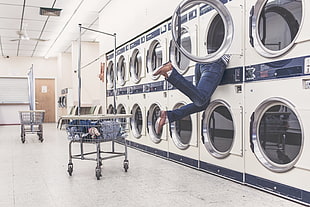 photography of woman getting clothes on washing machine