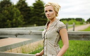 woman in gray button-up shirt near green grass field