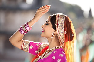 woman raising right hand wearing traditional dress