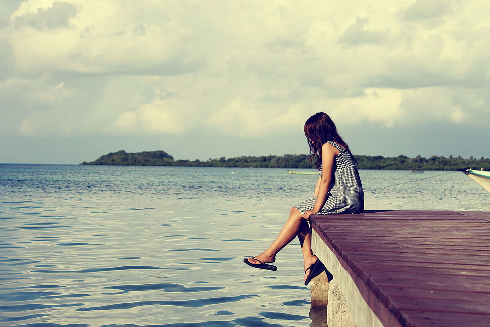 woman sitting on brown wooden bridge dock during daytime HD wallpaper