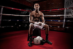 photo of a male boxer sitting on chair inside the boxing ring