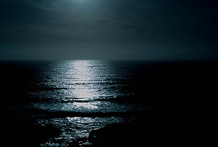 ocean wave under moonlight at nighttime