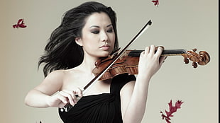 woman wearing black one-shoulder dress while playing violin