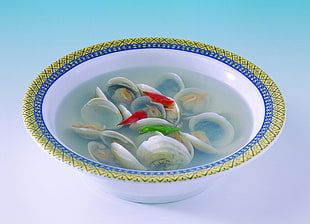 cooked clam shells in white, blue, and yellow bowl