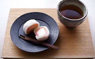 two white sushi on black ceramic plate