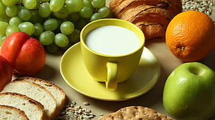 yellow ceramic mug with saucer filled with white liquid