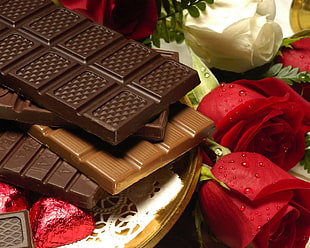 Chocolate bars near red Roses
