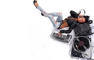 woman lying on a terminal mixer while holding a electronic keyboard