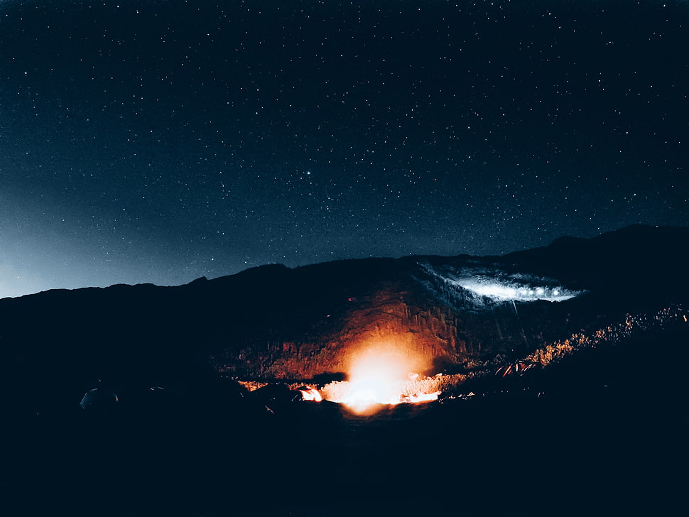 fire in the middle of mountains during nighttime HD wallpaper